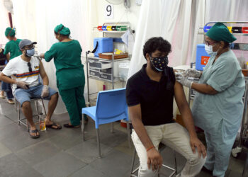 Medics inoculate doses of COVID-19 vaccine to people