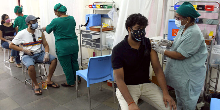 Medics inoculate doses of COVID-19 vaccine to people